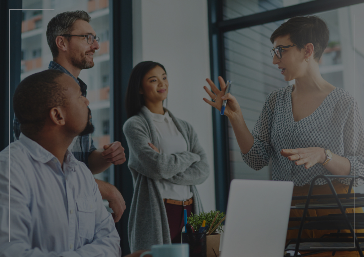 coworkers standing around desk talking