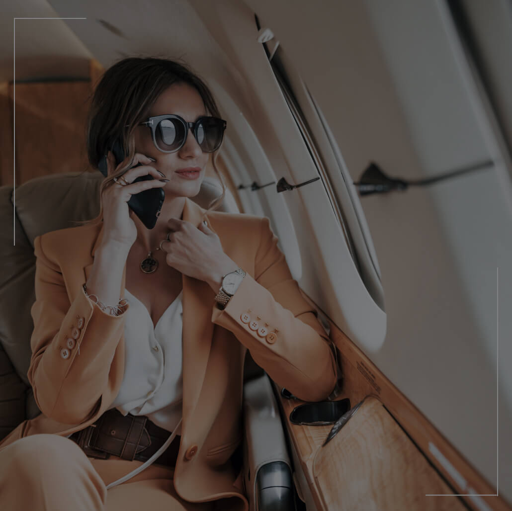 A business woman sits in an airplane while on the phone. A business woman sits in an airplane while on the phone.